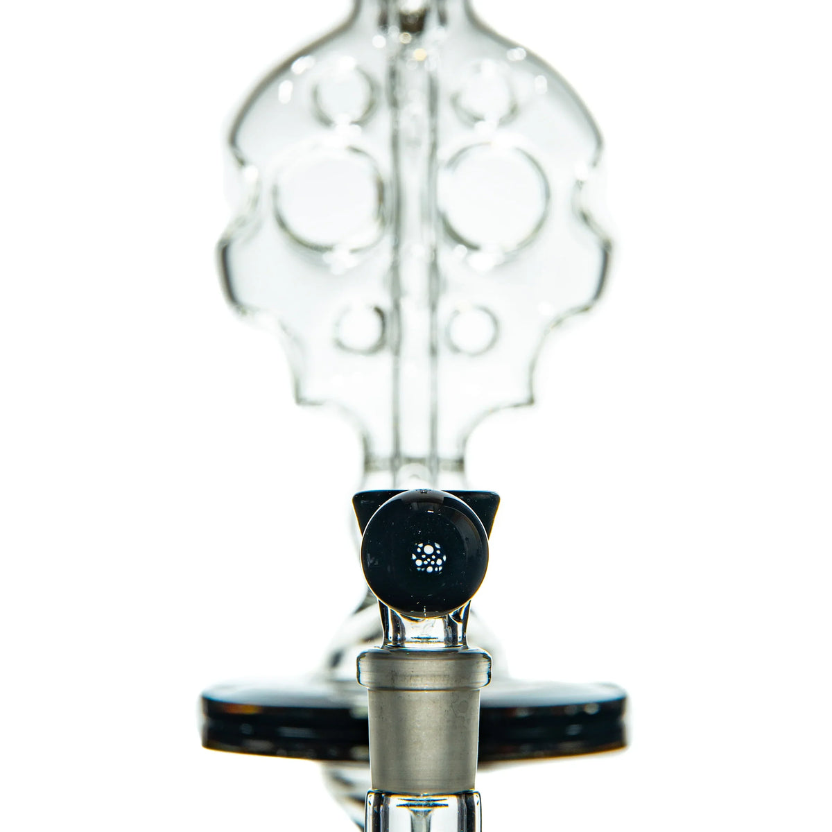 Close-up of intricate clear glass water pipe with unique percolator design, studio background