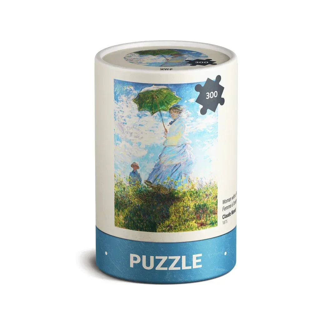 Cylindrical puzzle box featuring Monet's Woman with a Parasol painting, 300-piece jigsaw.