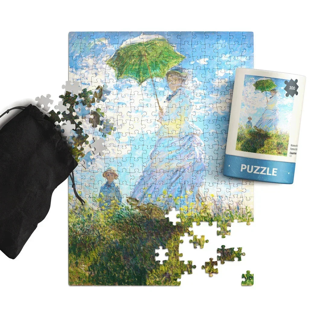 Impressionist art puzzle with woman holding green parasol, scattered pieces and storage pouch