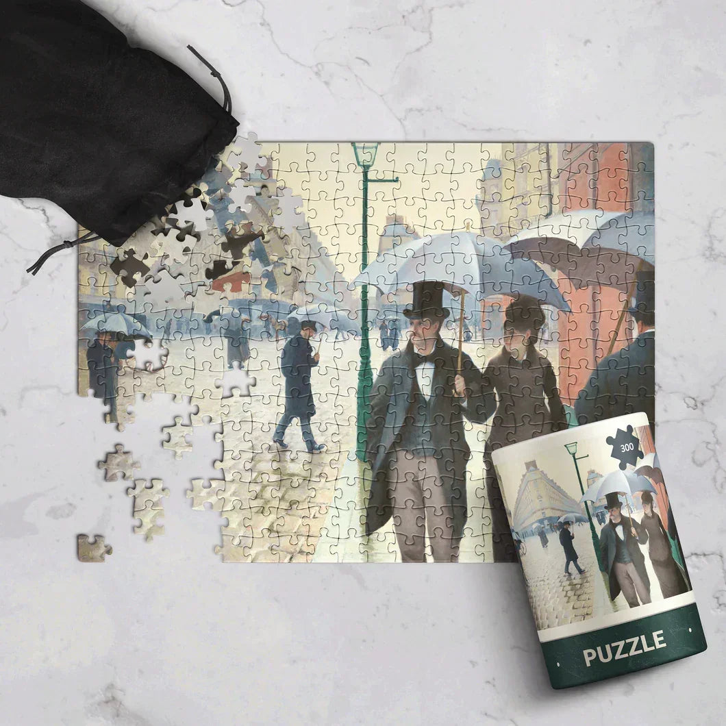 300-piece Paris street scene jigsaw puzzle with vintage umbrellas, partially assembled on marble