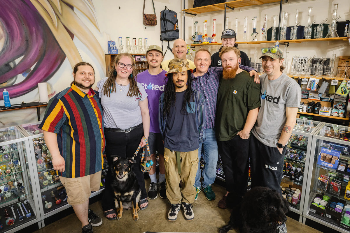 Stoked staff posing with two dogs in athe retail store setting