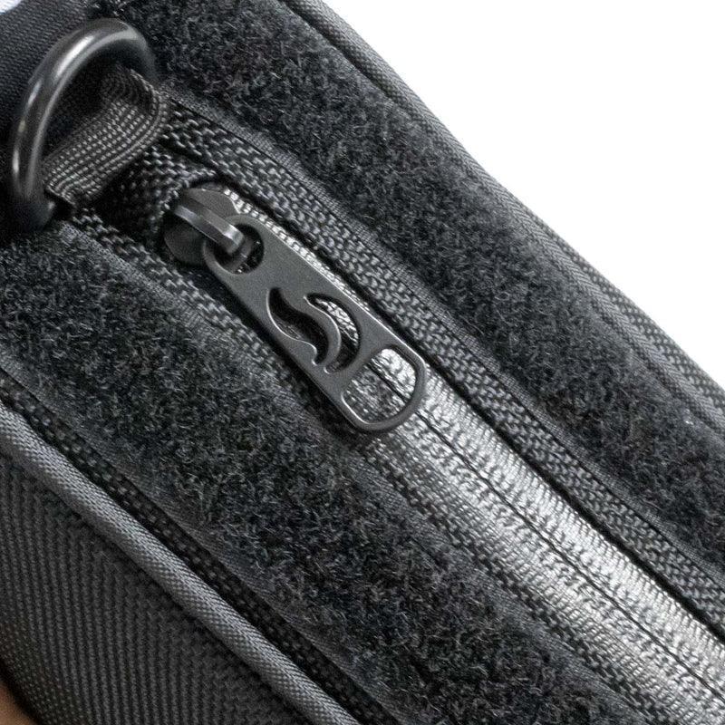 Close-up of black travel pouch zipper with textured fabric and D-ring attachment