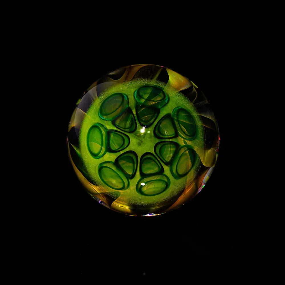 Artistic green and yellow glass marble with intricate swirling patterns on black background