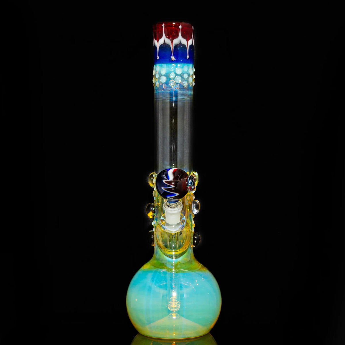 Fumed glass beaker bong with colorful accents and decorative marbles against black background