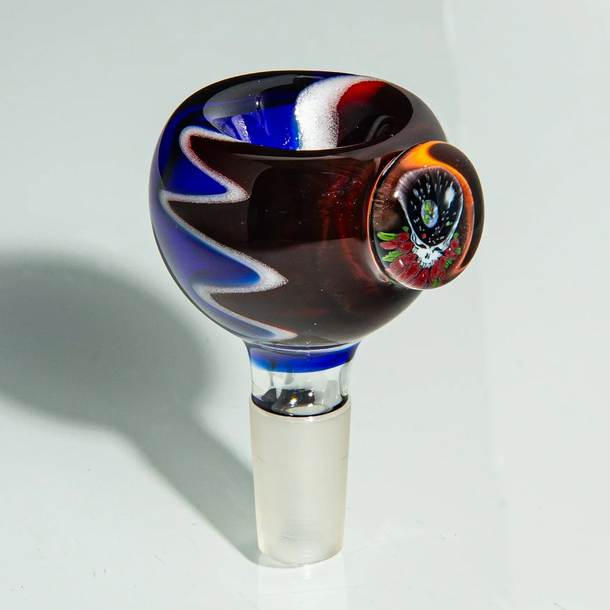 Colorful glass bong bowl slide with blue, red, and white swirls and a decorative marble
