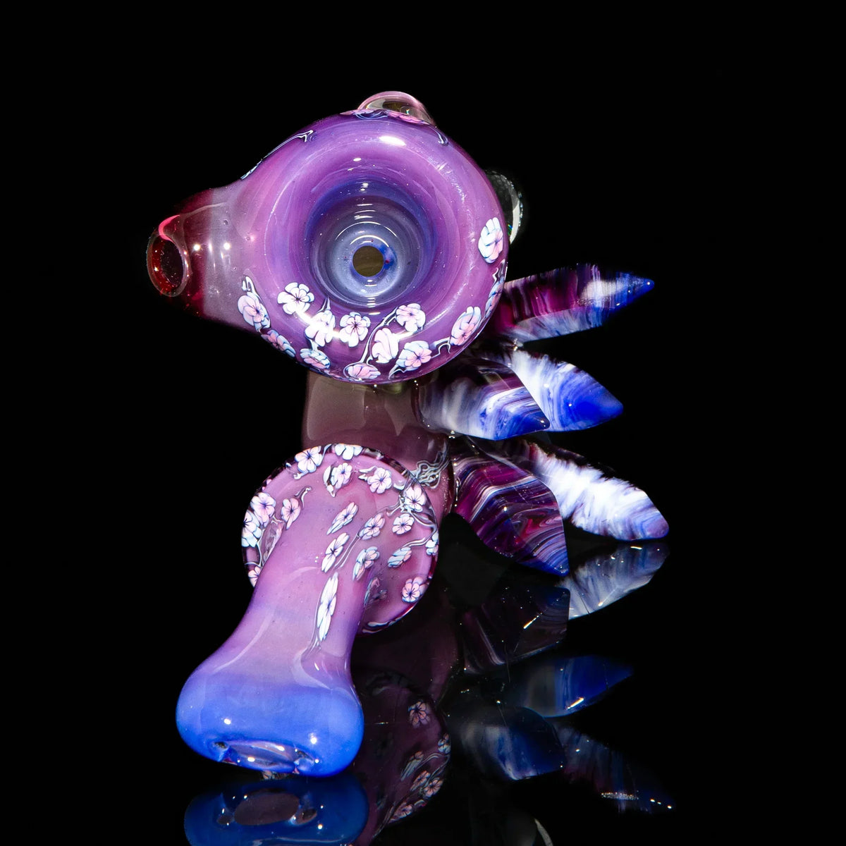 Purple and blue hand-blown glass pipe with floral designs and crystal-like accents on black background