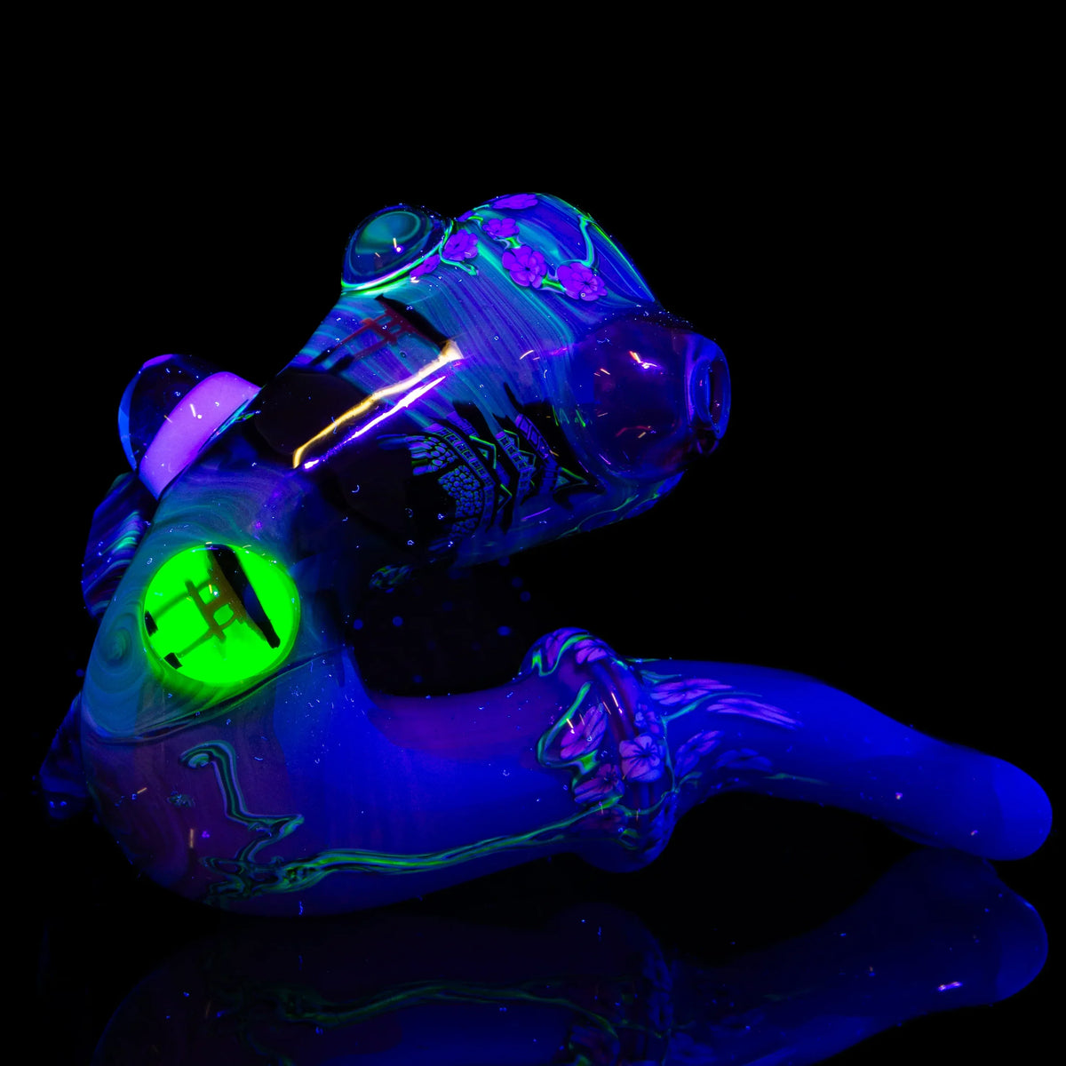 UV reactive heady glass pipe with neon green and purple accents on black background