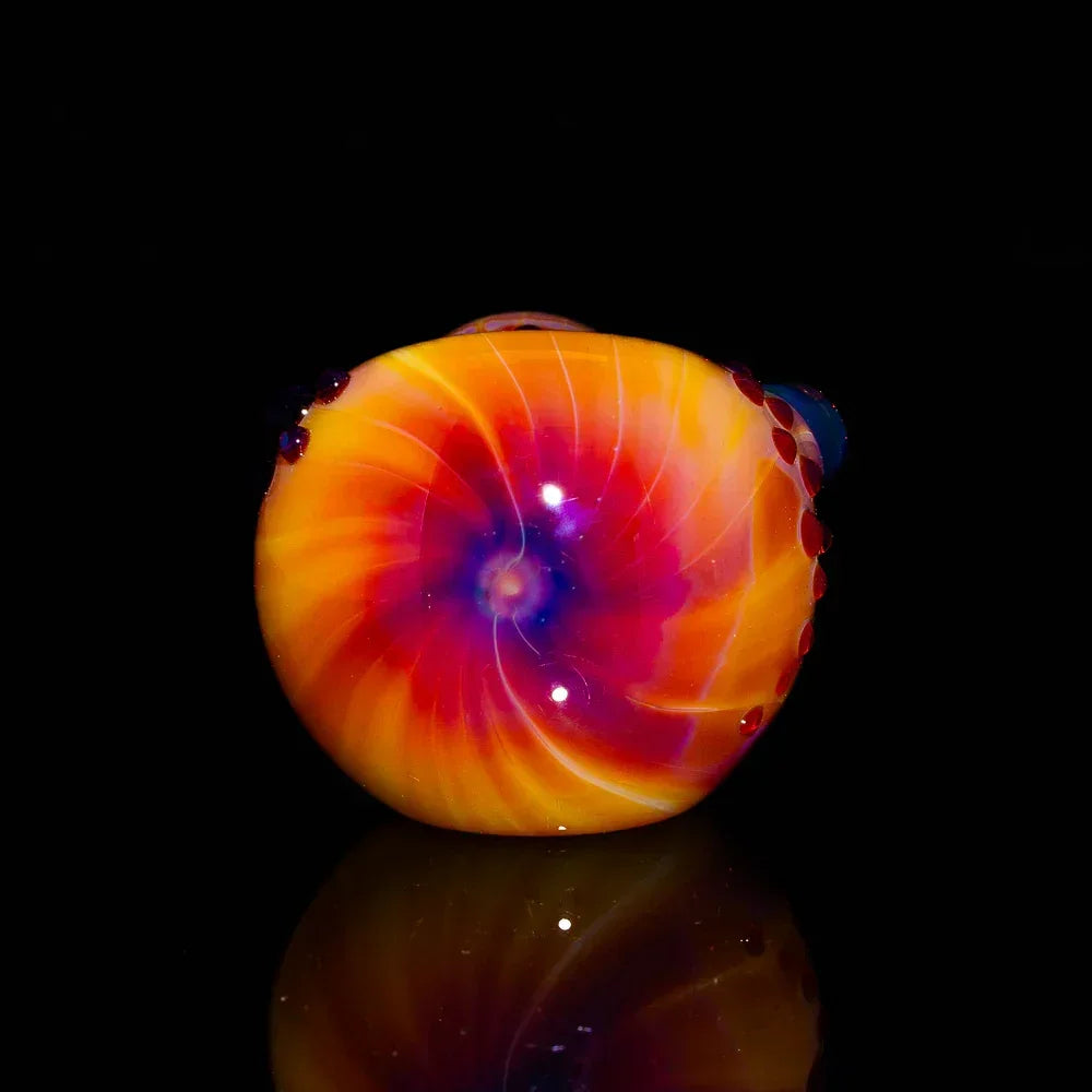 Colorful hand-blown glass spoon pipe with vibrant orange, red, and purple spiral design
