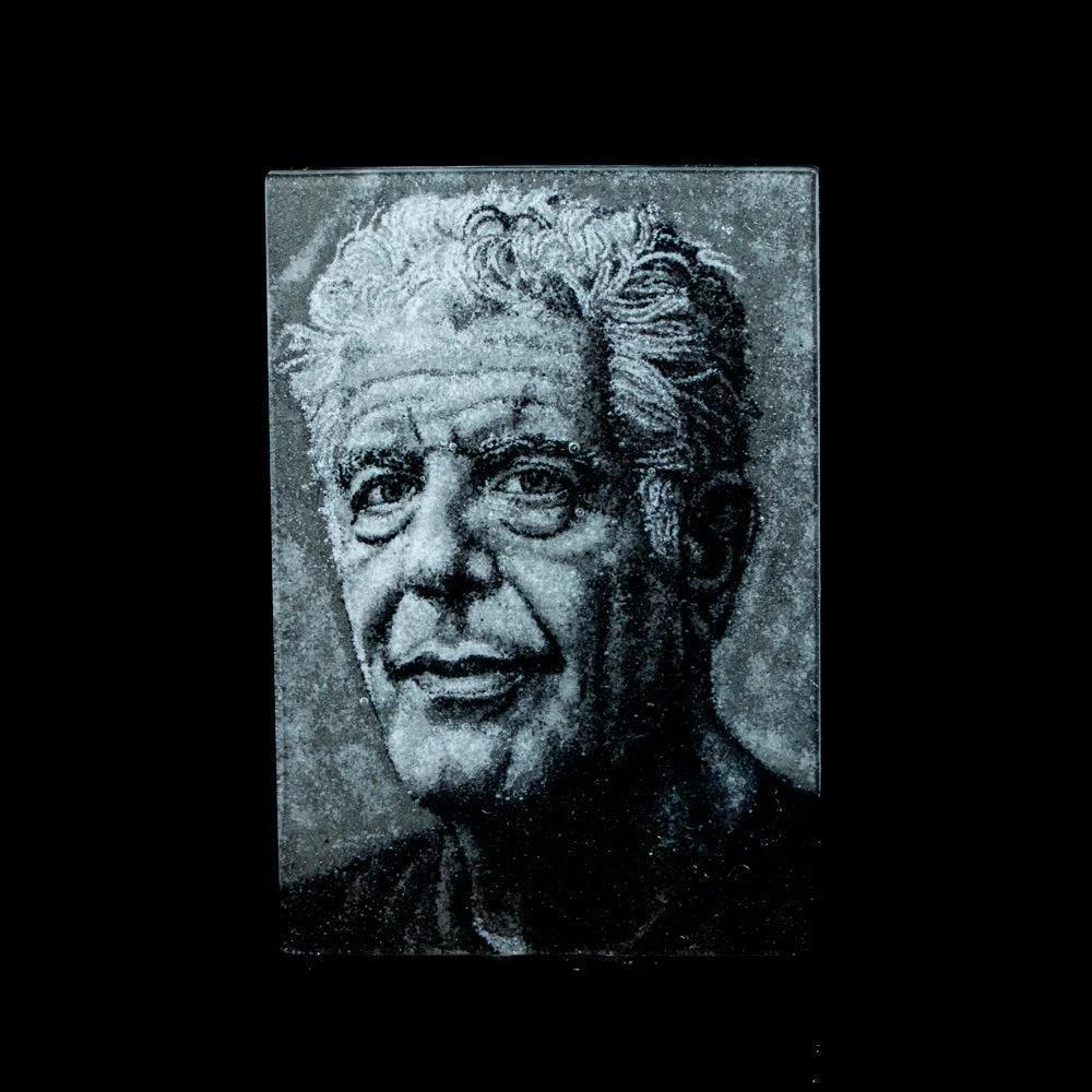 Etched glass portrait artwork of an older man with curly hair on a black background