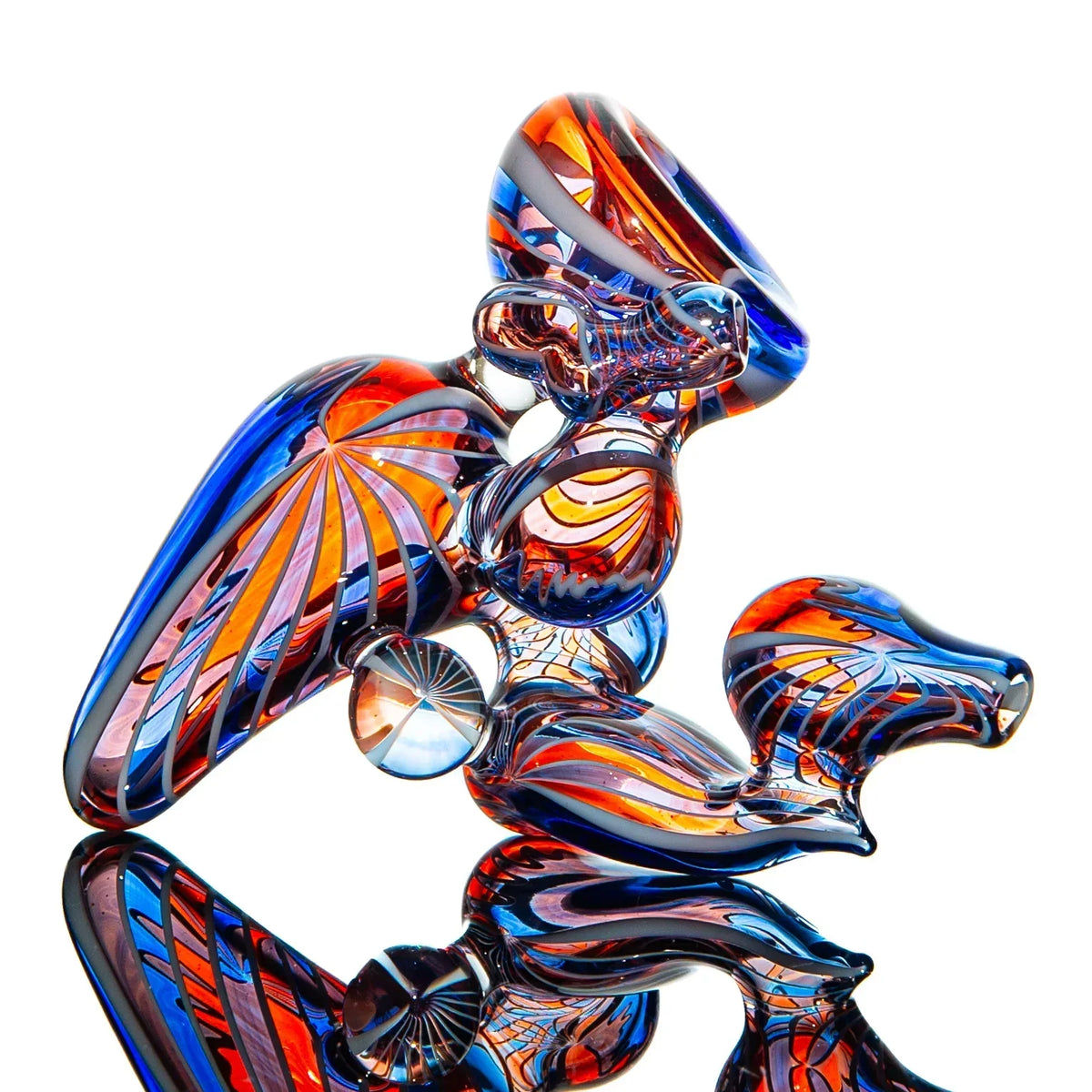 Colorful heady glass pipe with red, blue, and orange swirls on a reflective surface