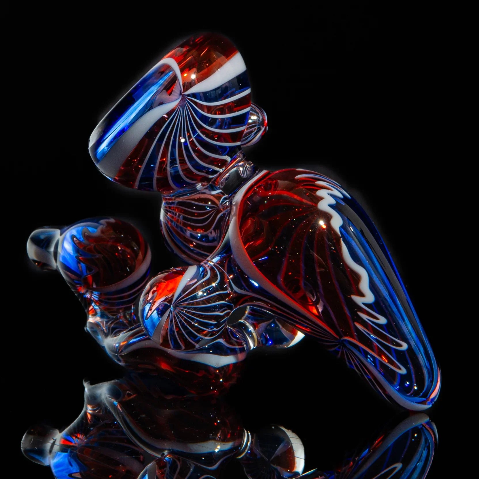 Red, white, and blue heady glass pipe with intricate swirl designs on black background