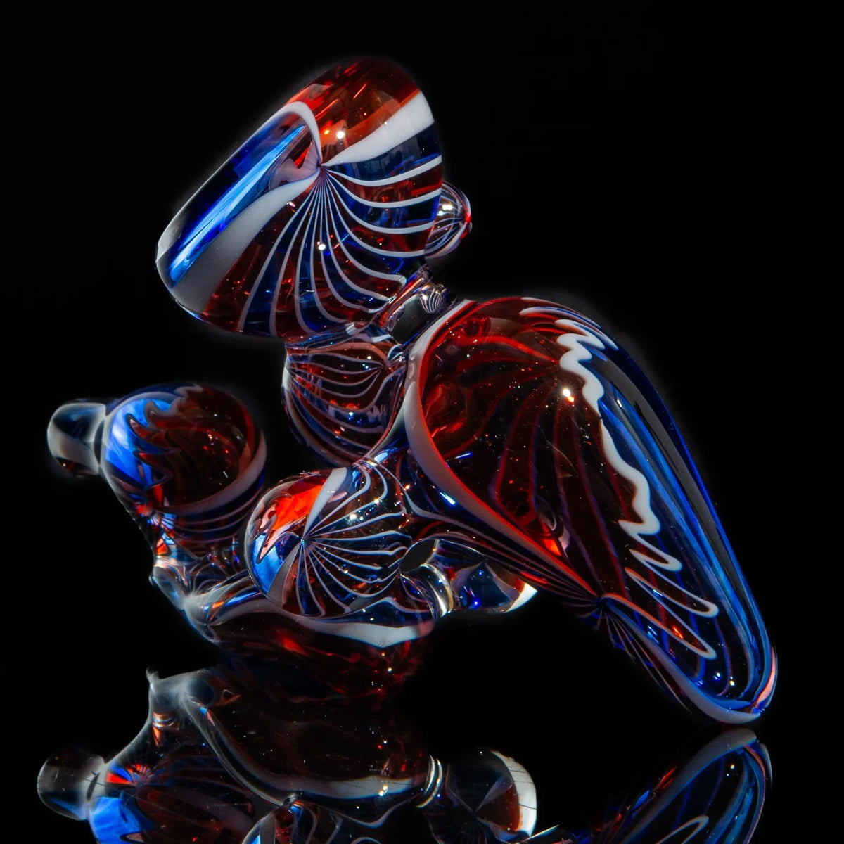 Red, white, and blue heady glass pipe with intricate swirl designs on black background