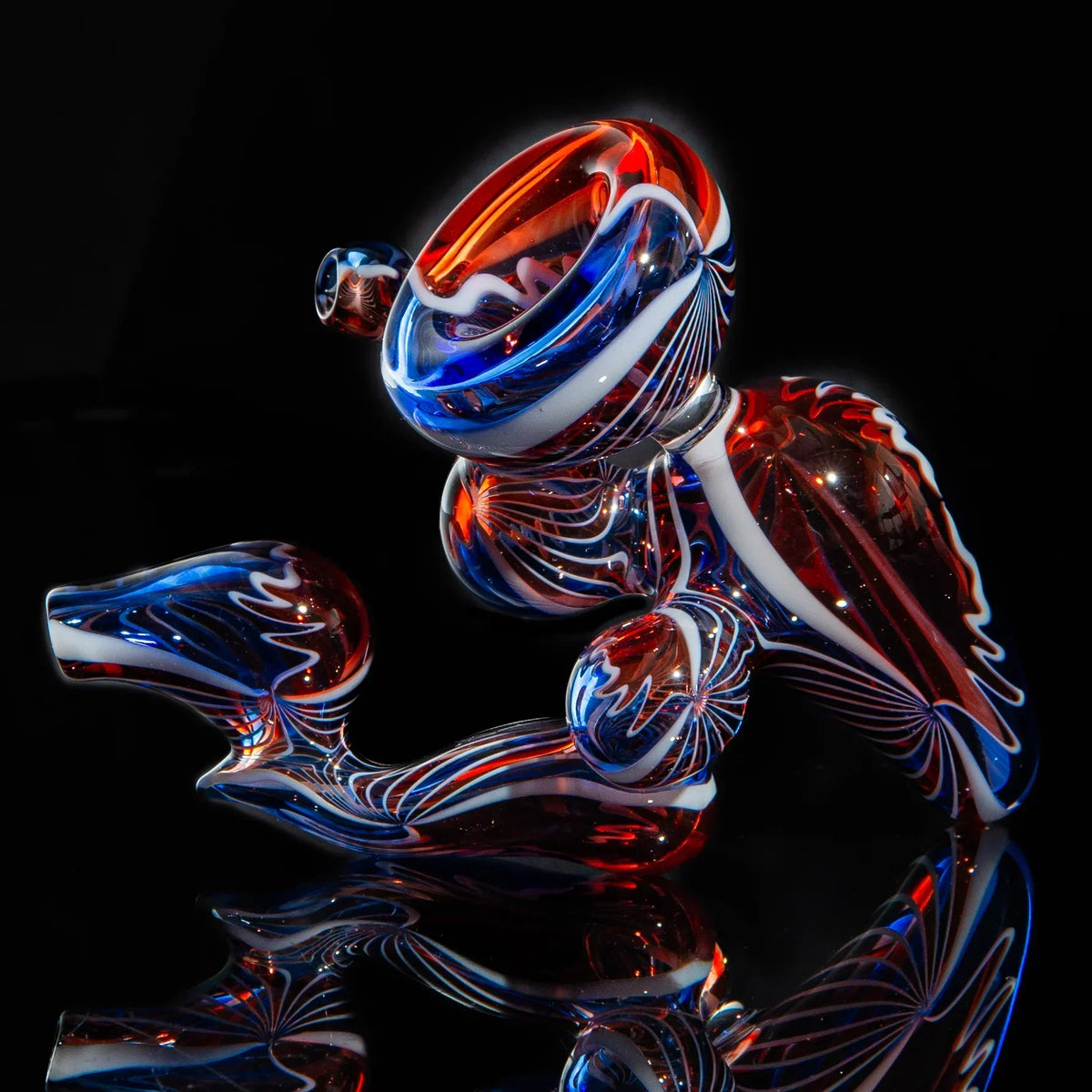 Hand-blown glass pipe with red, blue, and white swirled patterns on black background