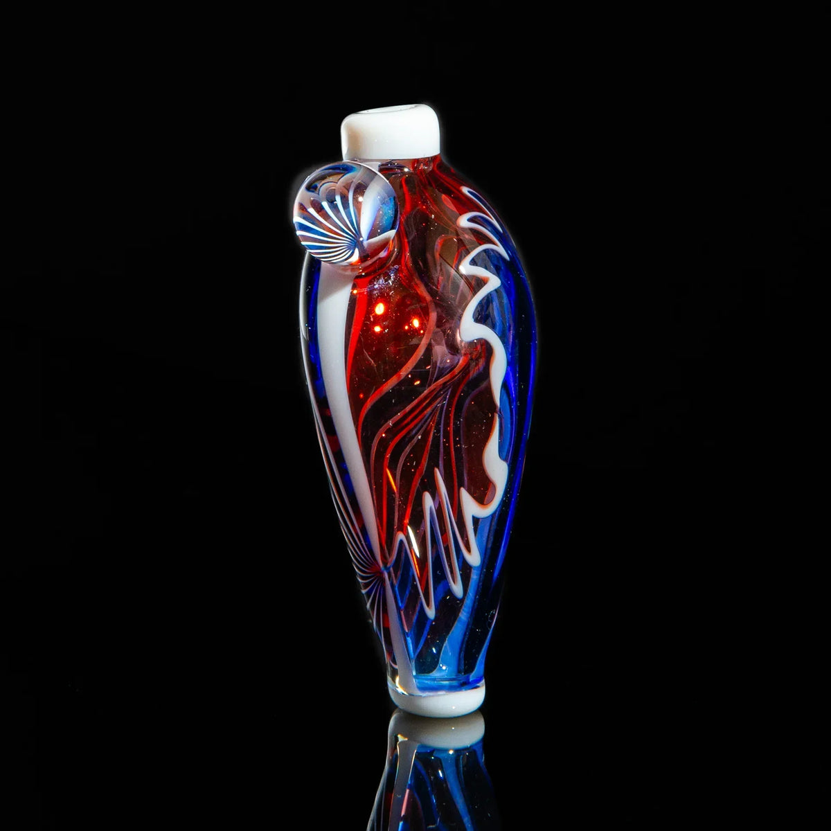 Colorful glass hand pipe with red, blue, and white swirl designs on black background