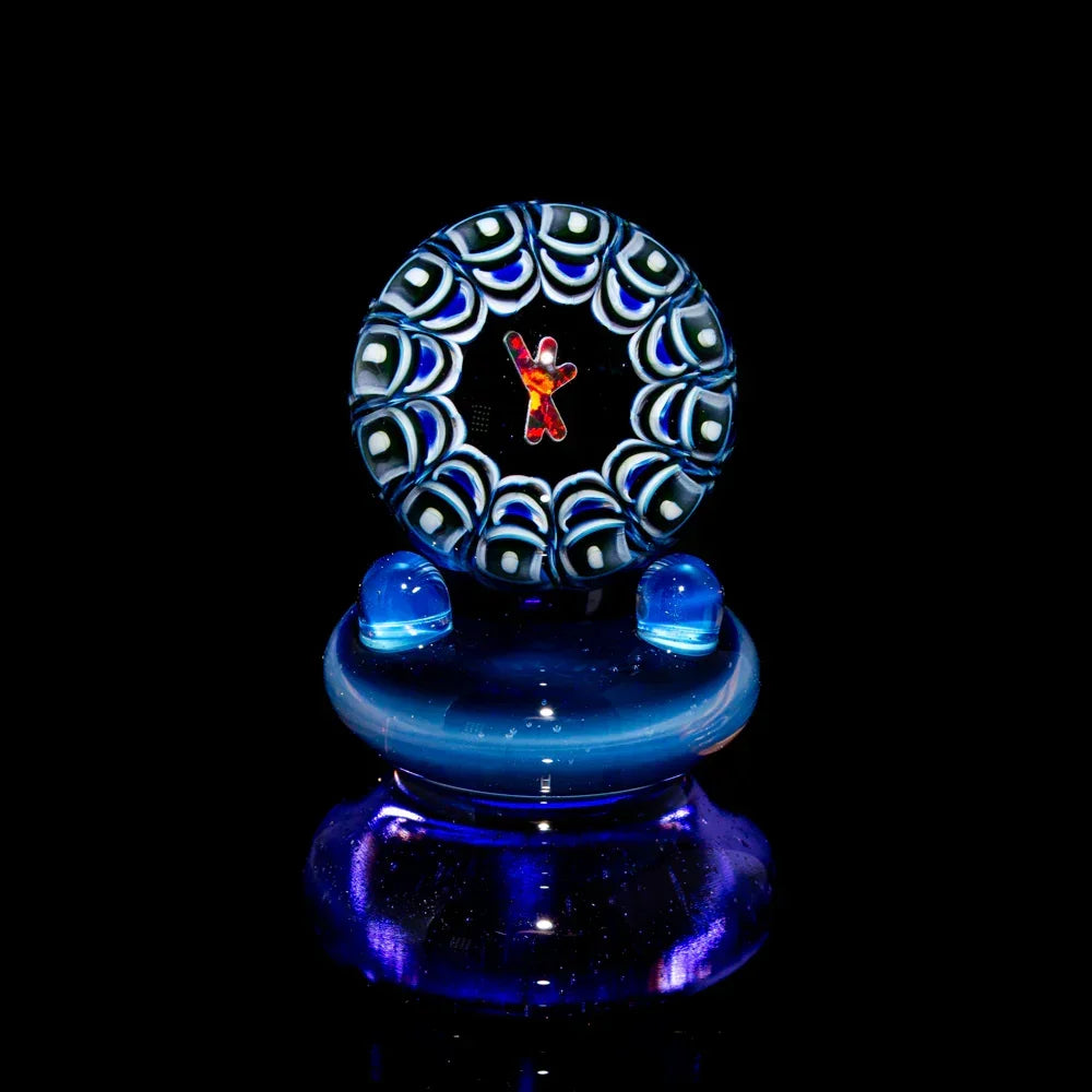 Handcrafted glass marble with intricate blue and white pattern and central red design