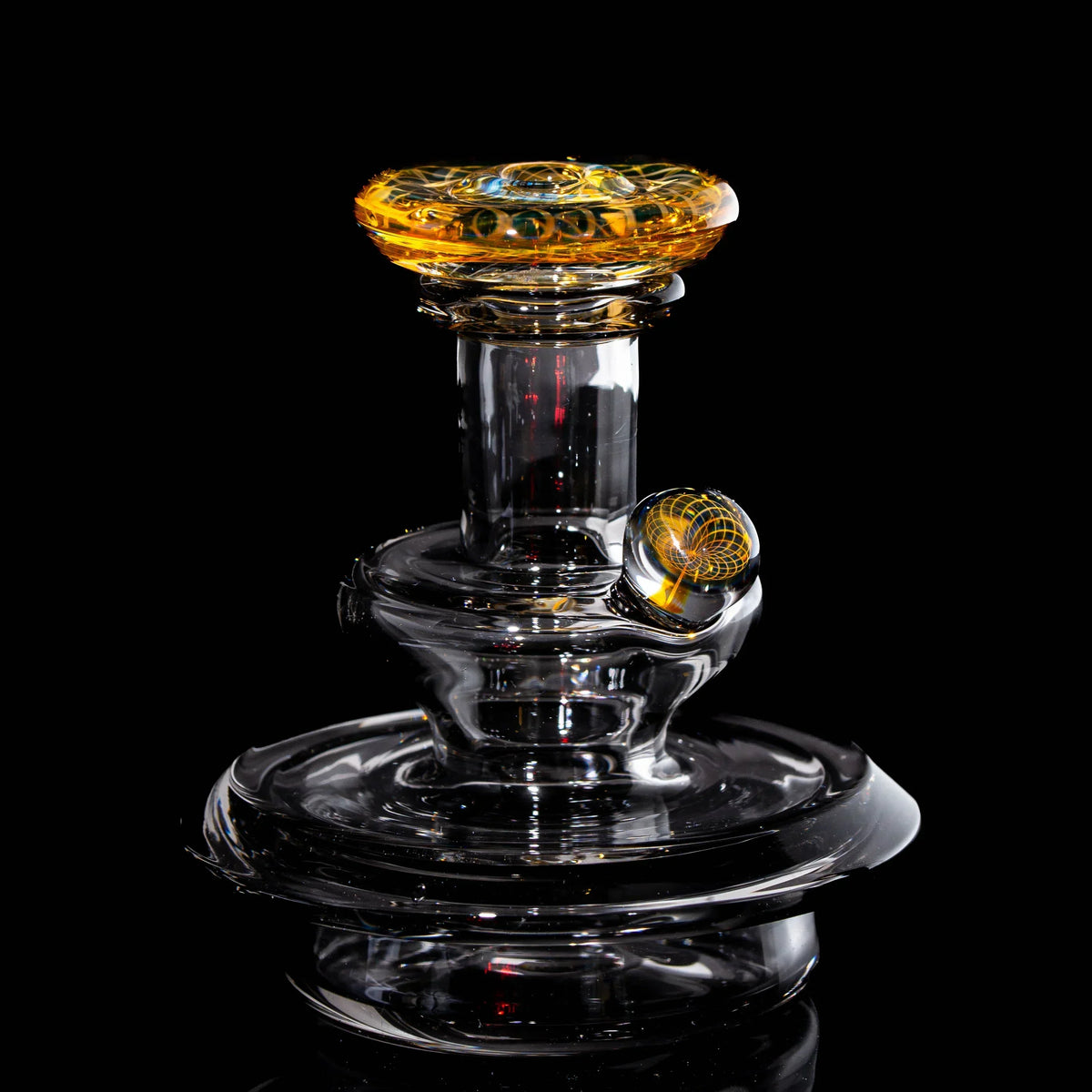 Heady glass water pipe with intricate amber and clear design on black background