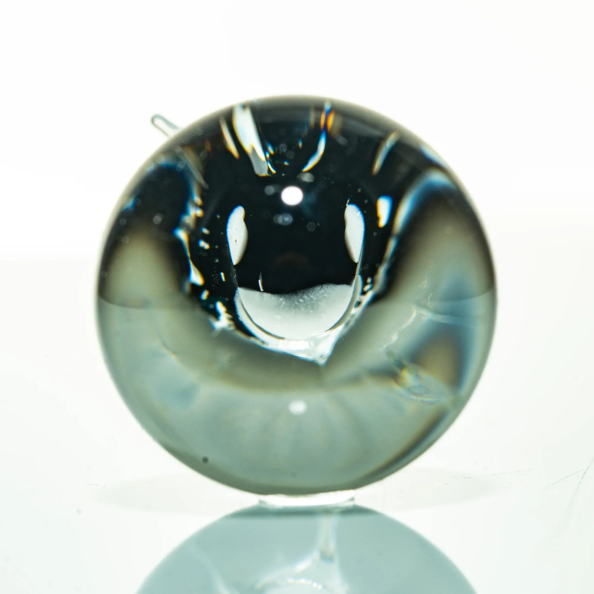 Handcrafted glass marble with abstract design, displayed on a white background