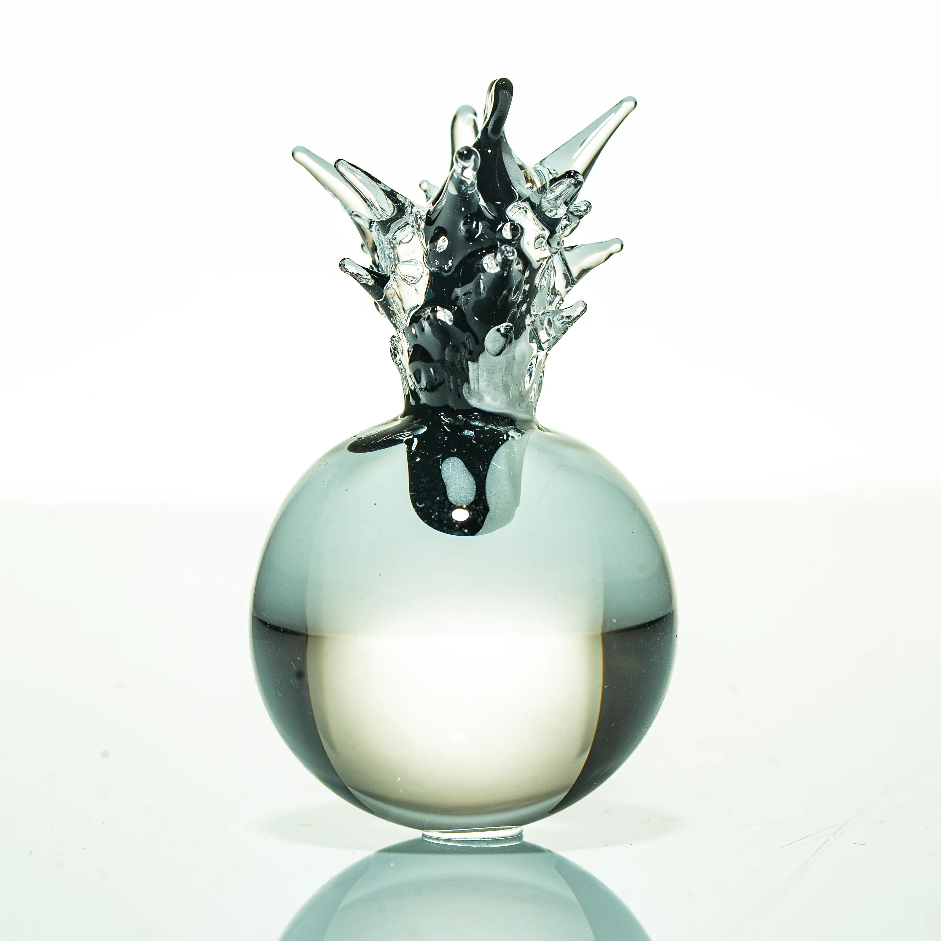 Artistic glass sculpture with abstract spiked design on white background