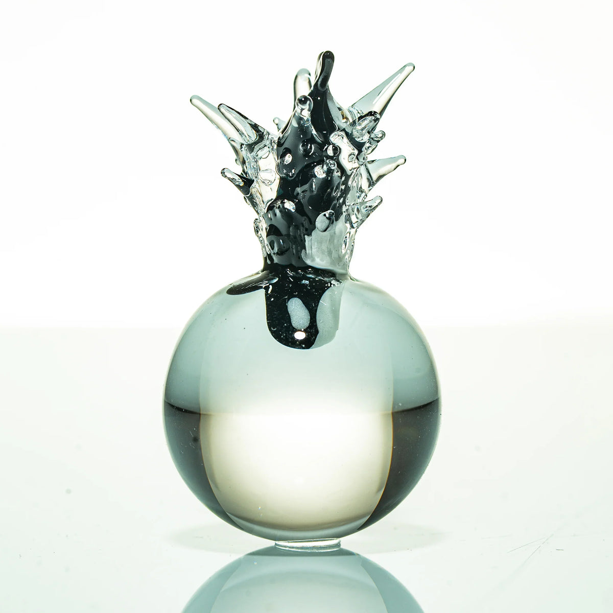 Artistic glass sculpture with abstract spiked design on white background