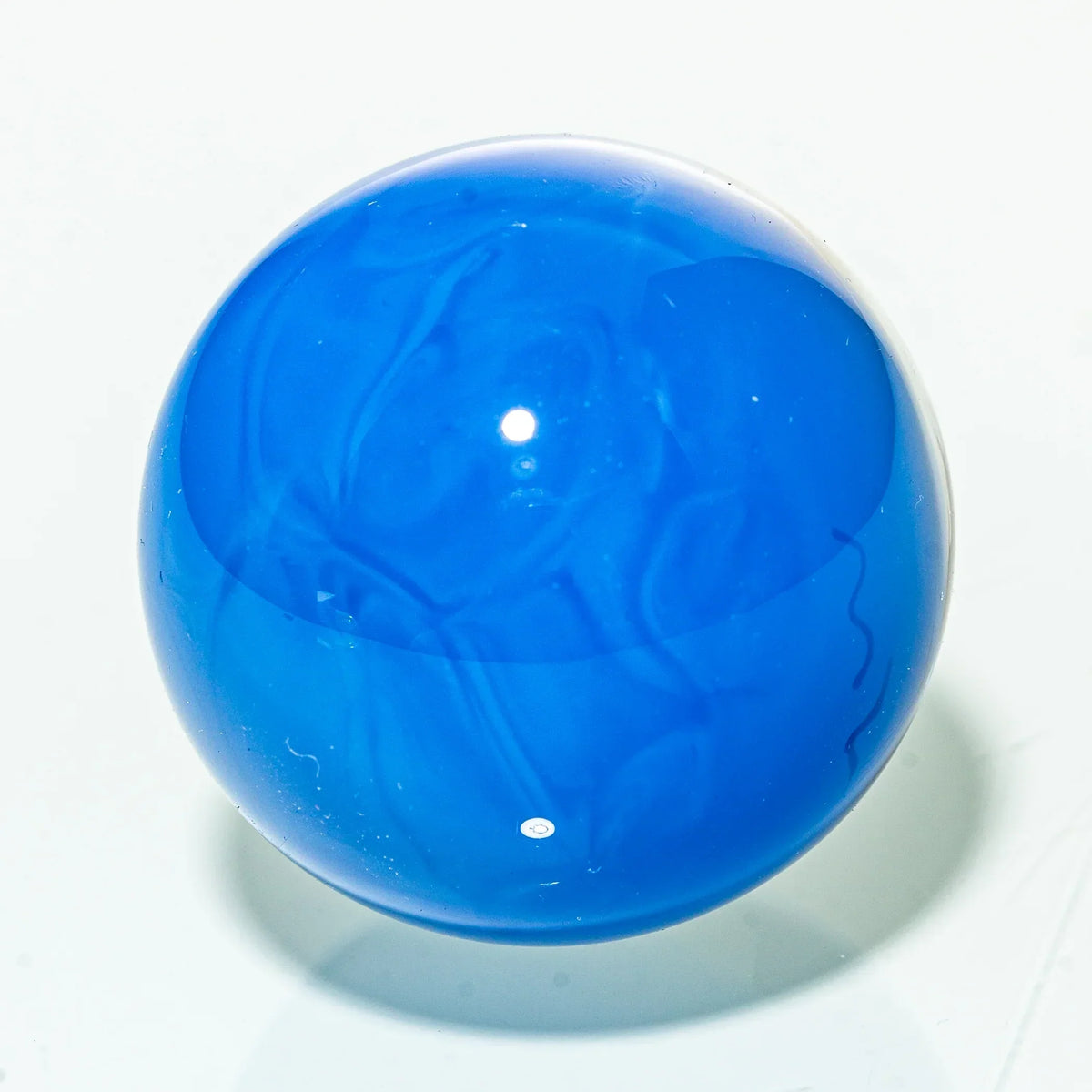 blue glass marble with swirled design on white background