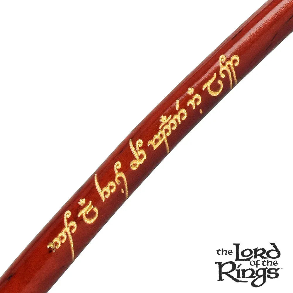 Close-up of a wooden pipe with Elvish script engraving and The Lord of the Rings logo.