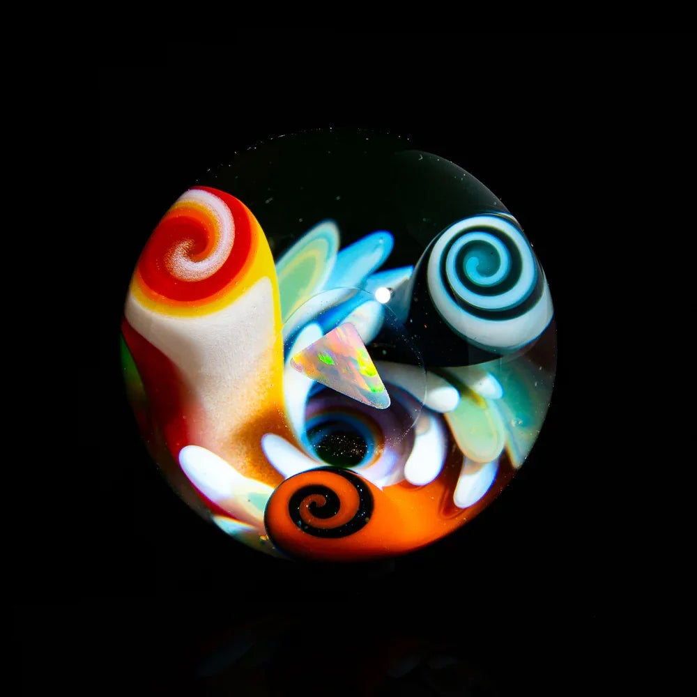 Colorful heady glass marble with vibrant swirls and opal inlay on black background