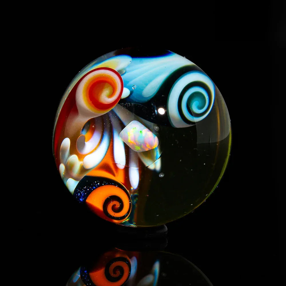 Heady glass marble with colorful swirl patterns and opal accent on black background