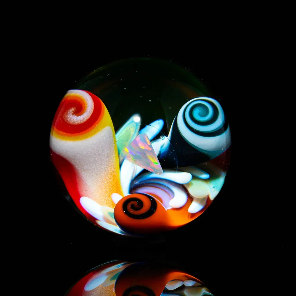 Colorful heady glass marble with swirling patterns and opal centerpiece on black background