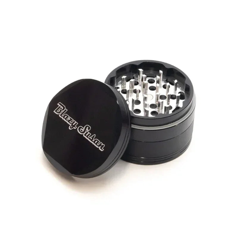 Black metal herb grinder with Blazy Susan logo, open to show sharp grinding teeth