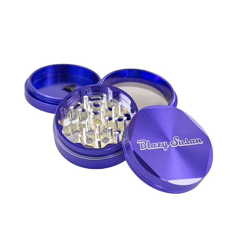 Purple metal herb grinder with Blazy Susan logo, open to show sharp grinding teeth.