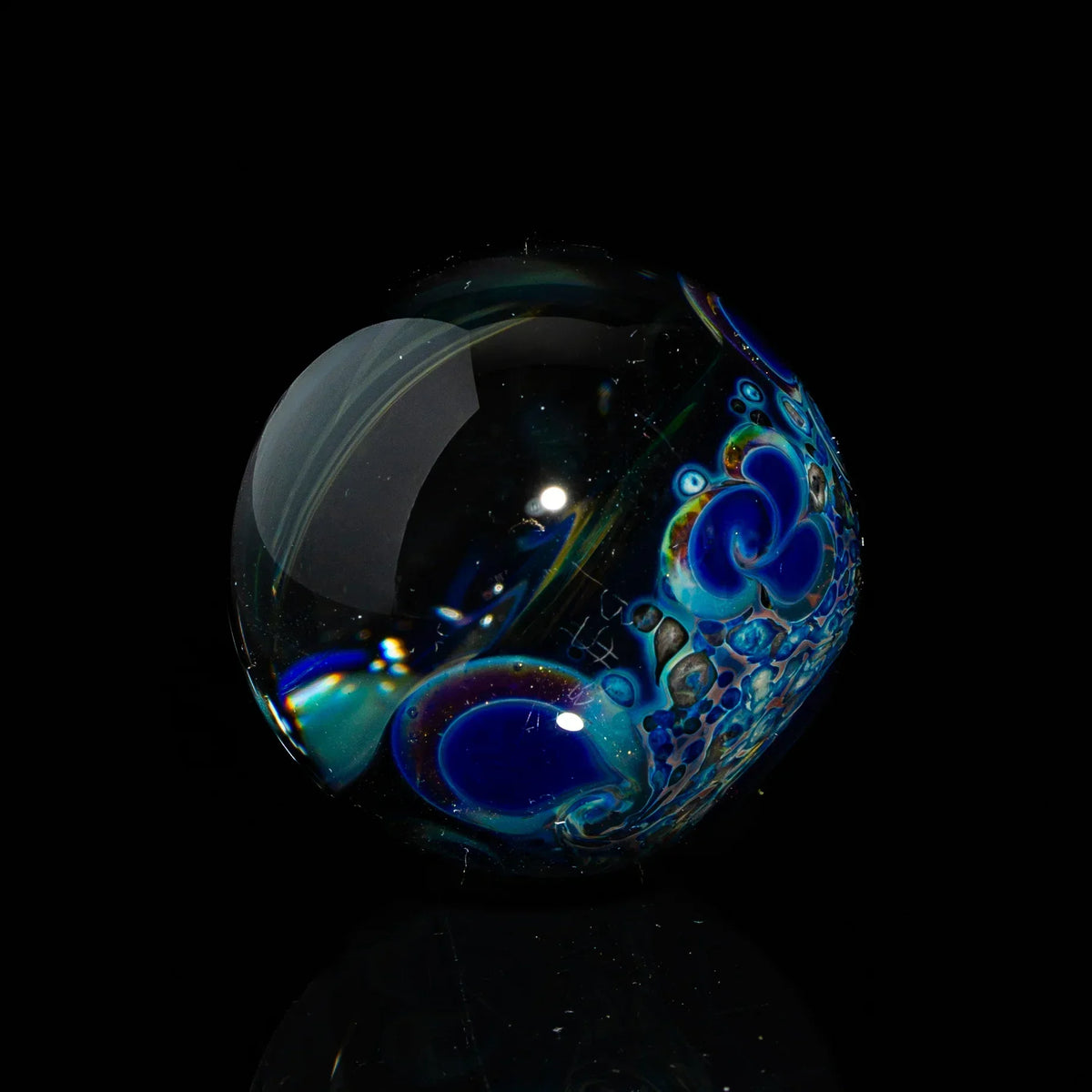 Heady glass marble with intricate blue and purple patterns on a black background