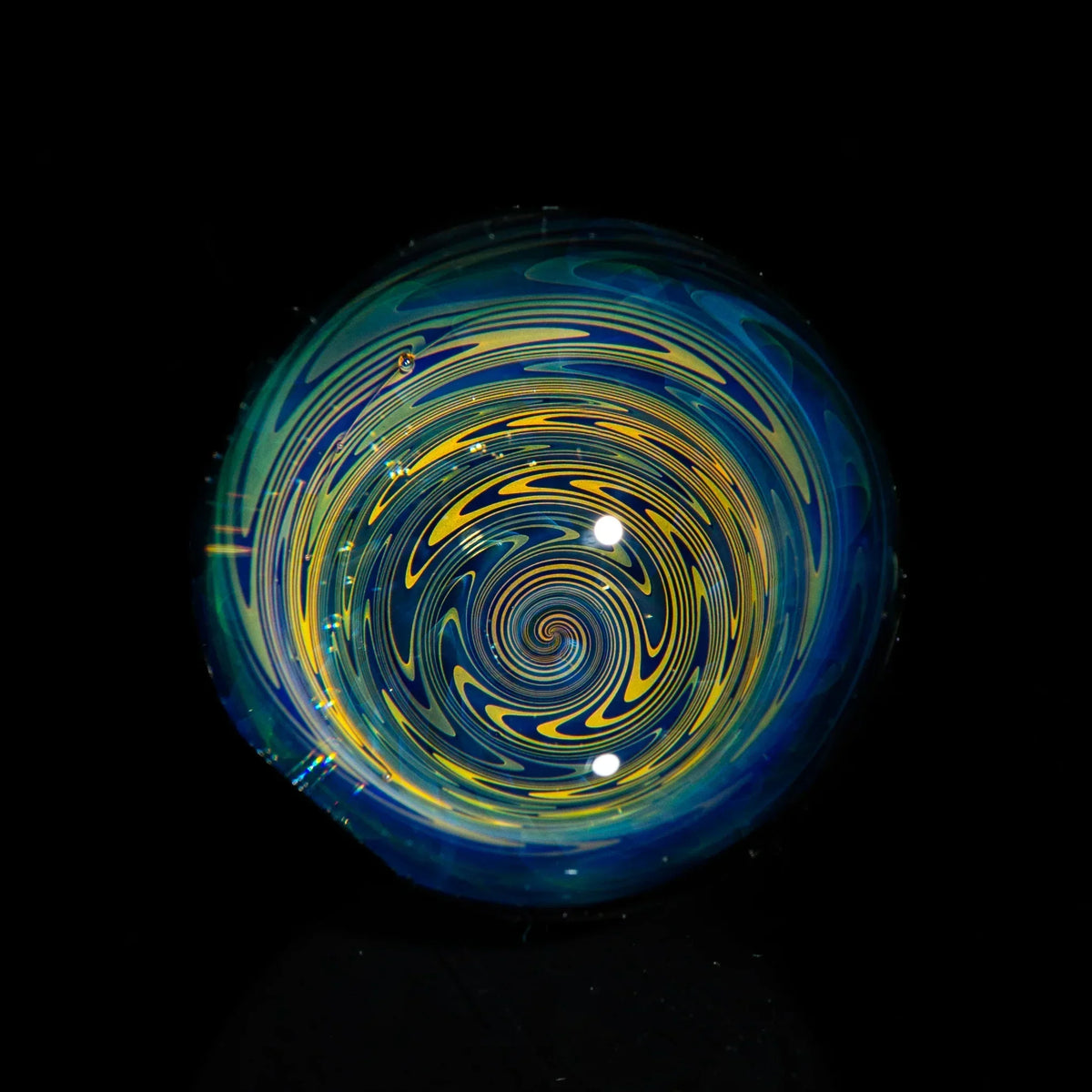 colorful heady glass marble with blue and yellow spiral design on black background