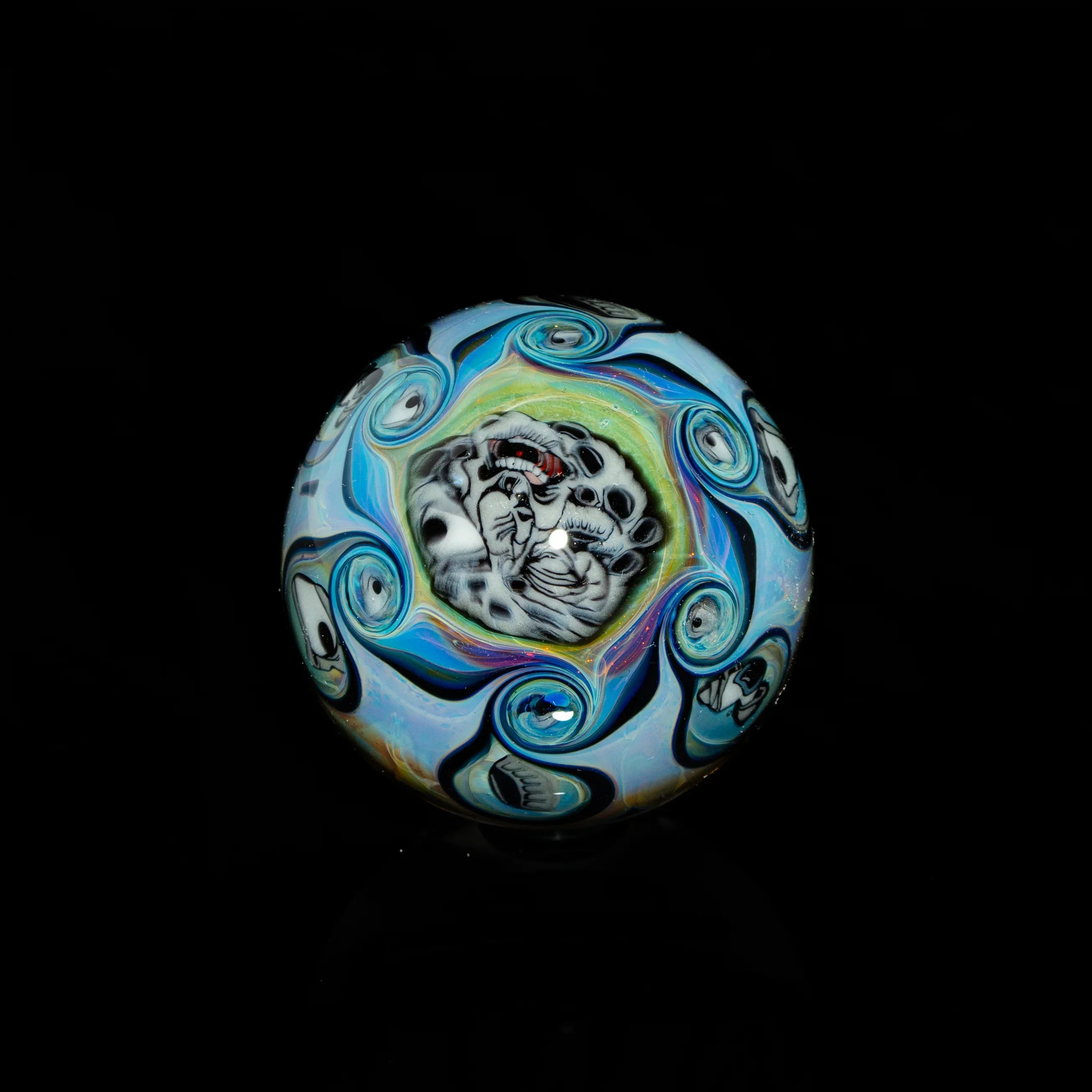 Handcrafted glass marble with swirling blue patterns and detailed leopard face design