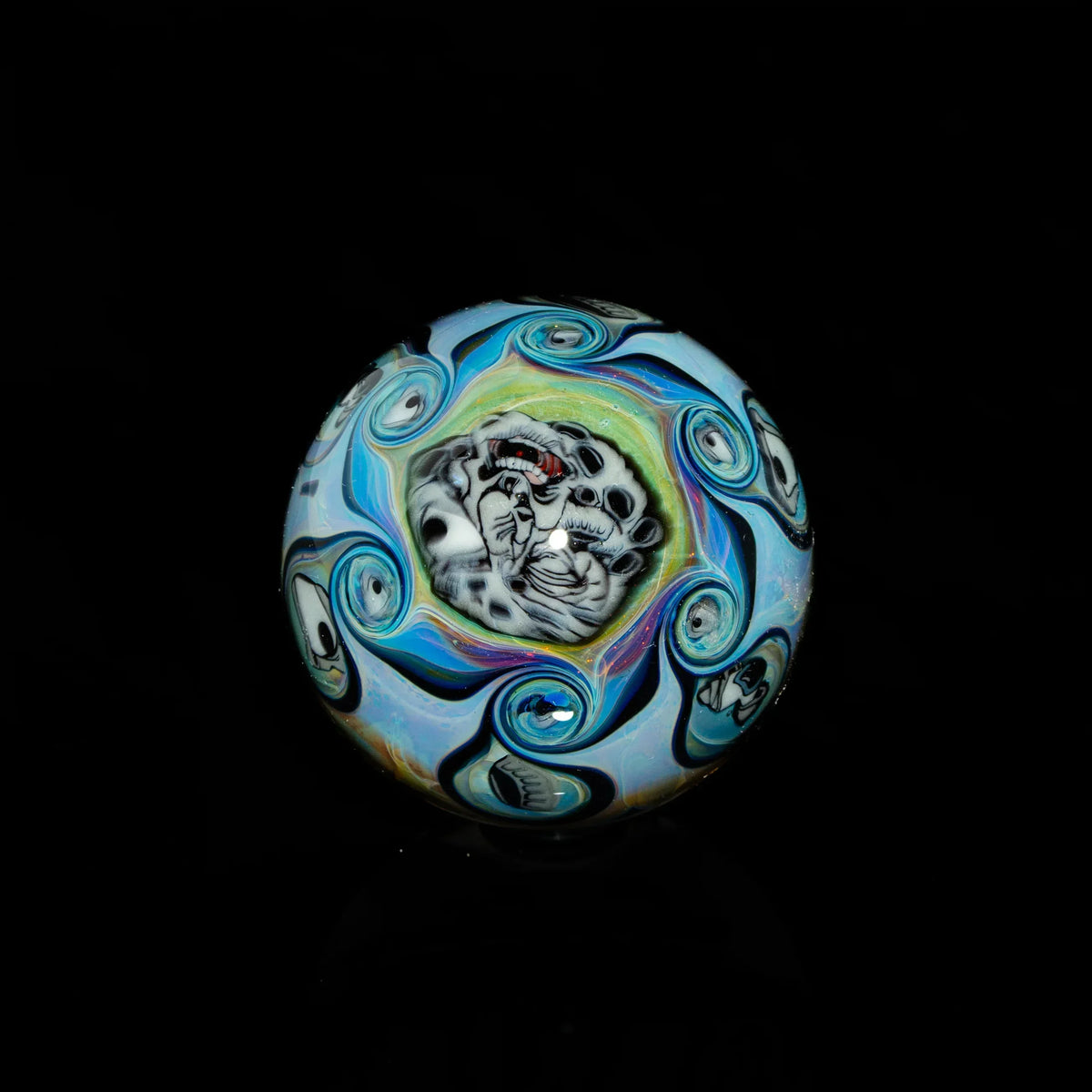 Handcrafted glass marble with swirling blue patterns and detailed leopard face design
