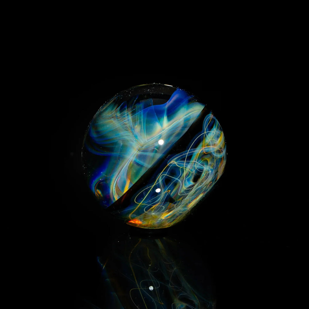 Heady glass marble with swirling blue, yellow, and orange patterns on a black background