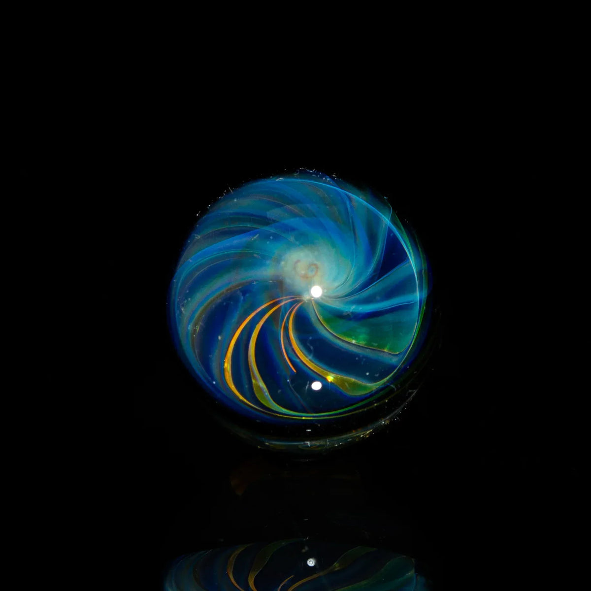 Heady glass marble with blue and yellow swirl design on a black background