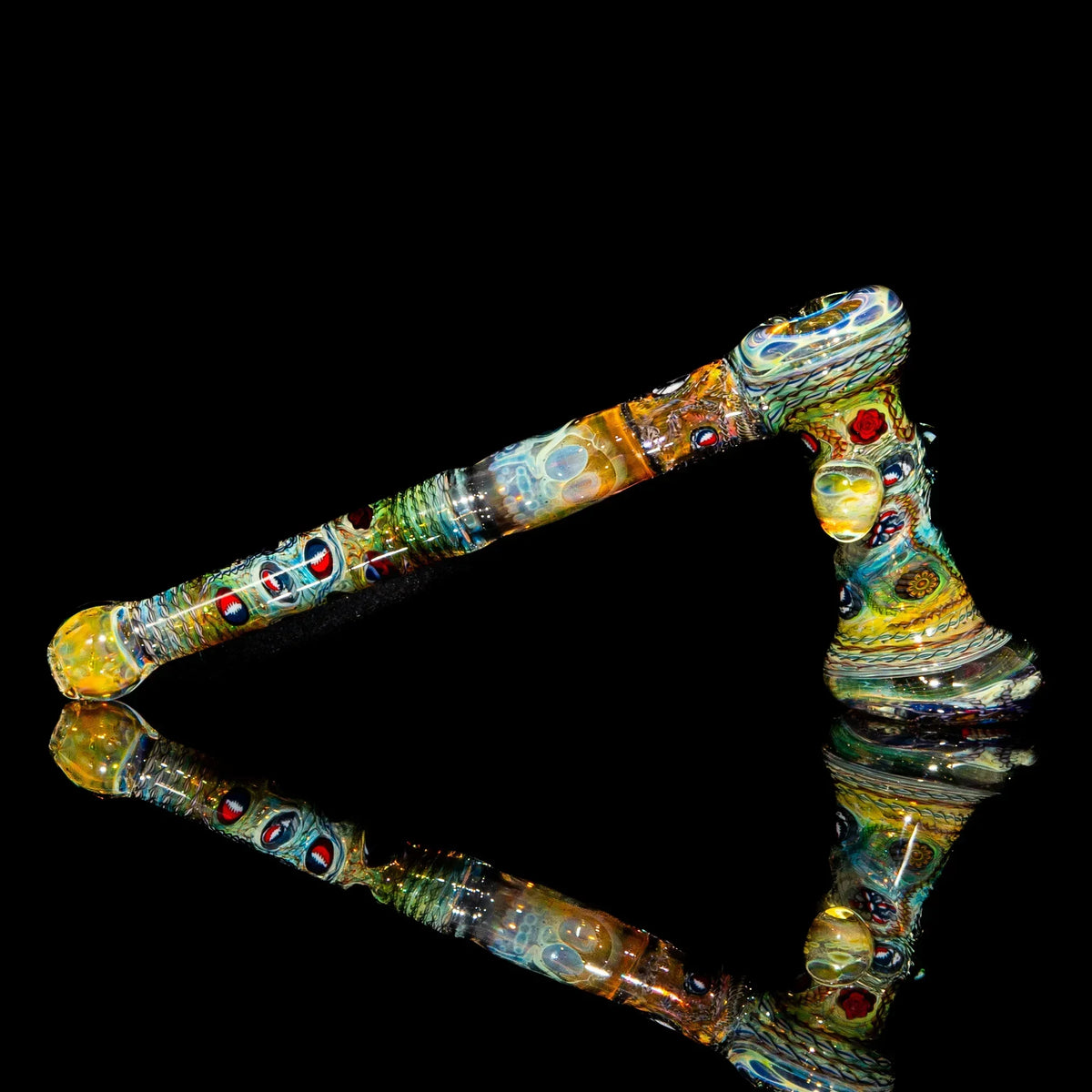 Colorful heady glass pipe with intricate patterns on a black reflective surface