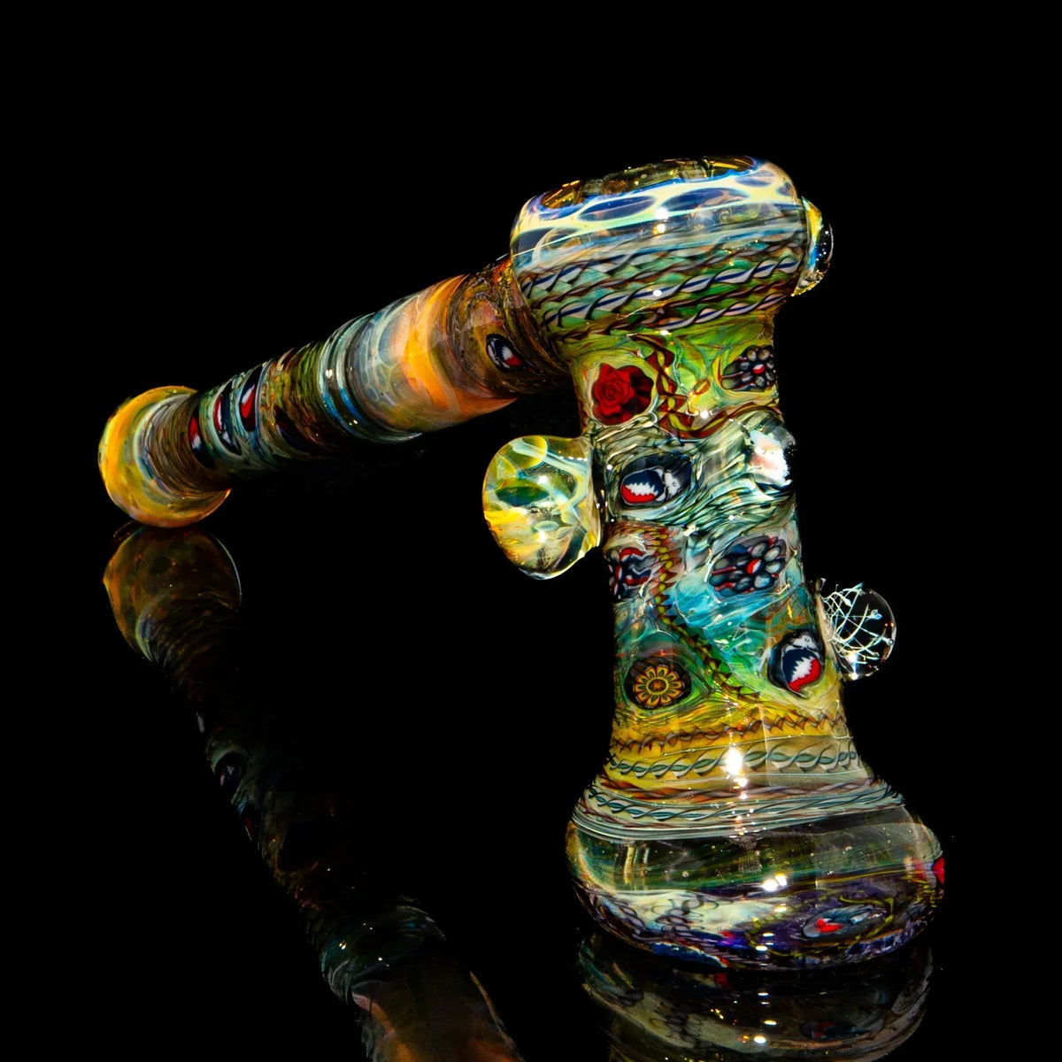 Colorful heady glass hammer pipe with intricate designs on black background