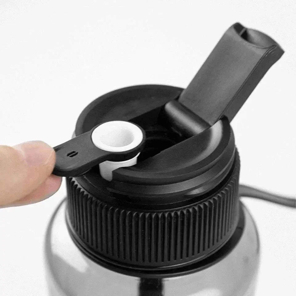 Close-up of a water bottle-style portable smoking device with open mouthpiece and ceramic bowl.