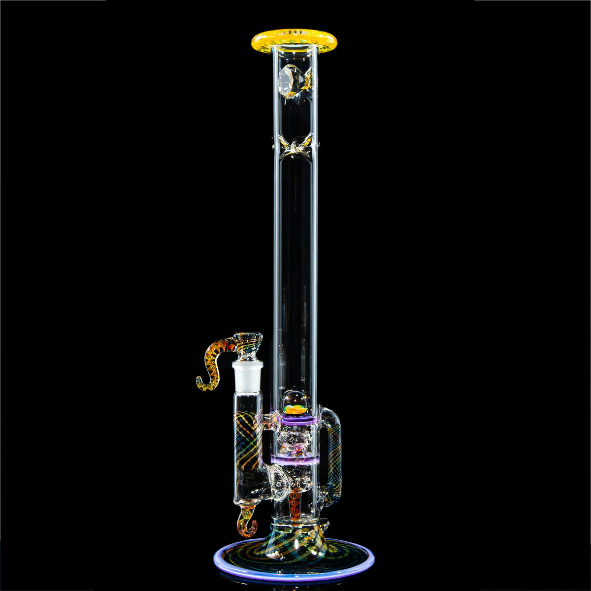 Intricate heady glass water pipe with colored accents and percolator against black background