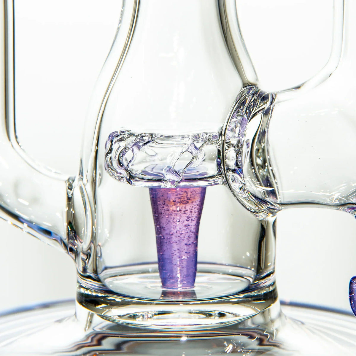 Close-up of a clear and purple glass water pipe percolator with intricate details