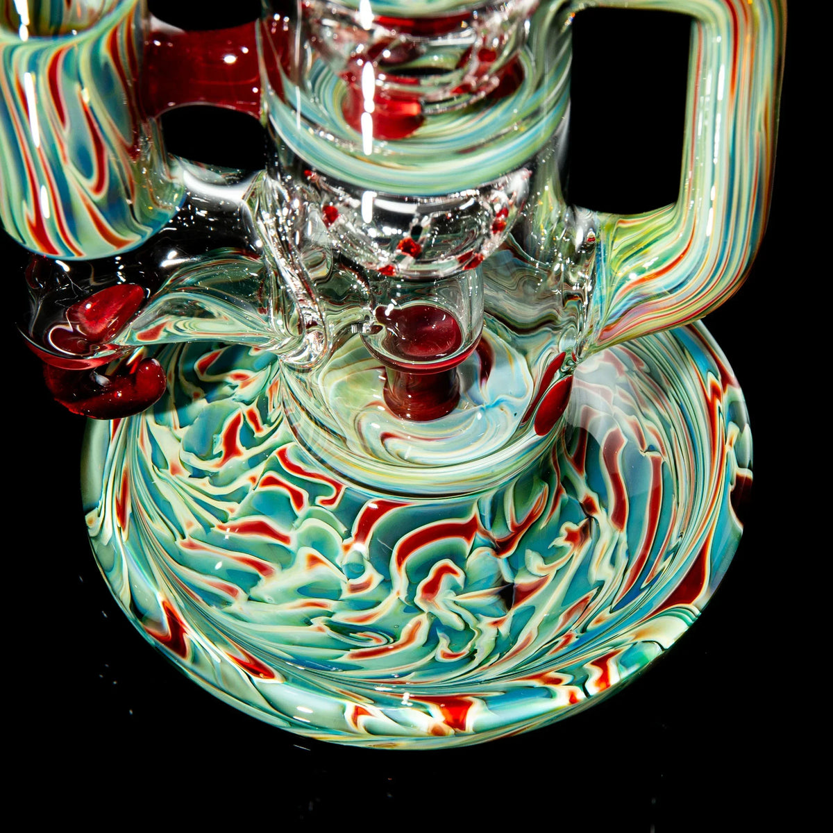 Heady glass water pipe with vibrant red, green, and blue swirl patterns on black background