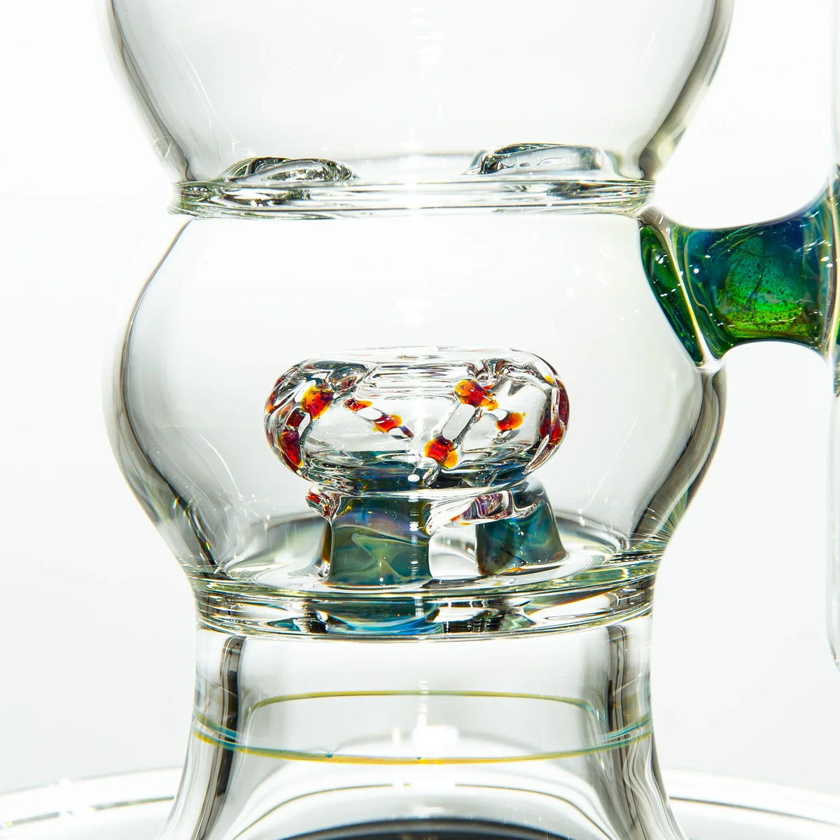 Close-up of intricate clear glass water pipe with colorful glass accents and percolator