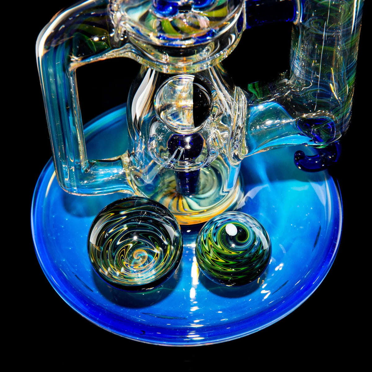 Handcrafted heady glass water pipe with intricate swirling designs on a blue base