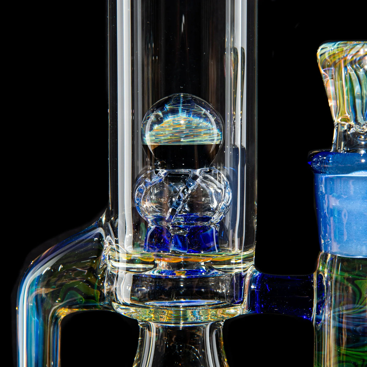 Close-up of a handcrafted glass water pipe with intricate blue and clear glass details
