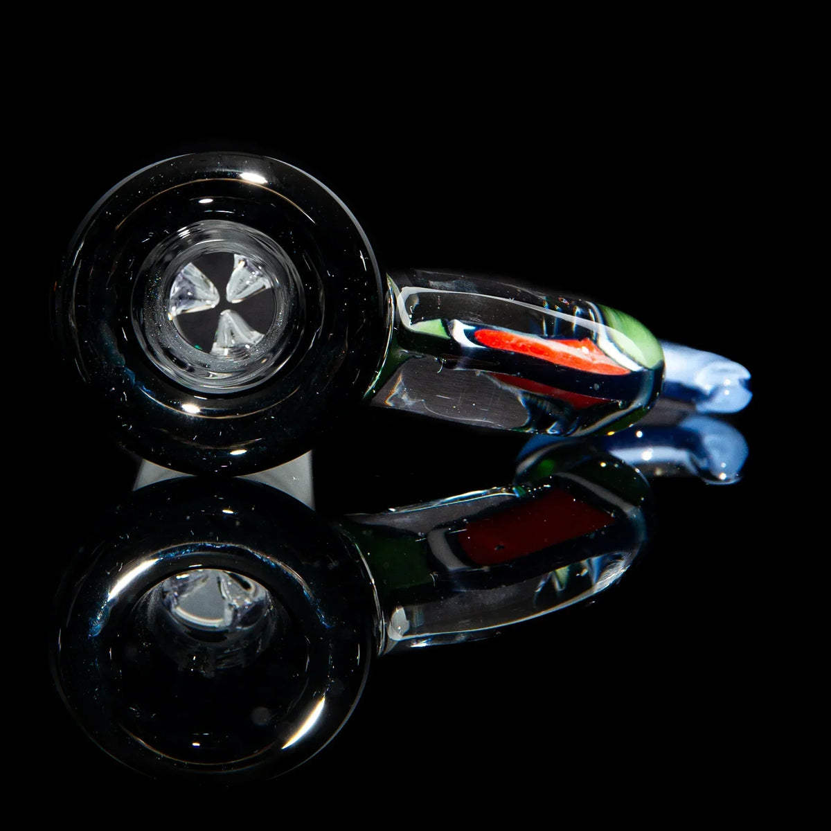 Handcrafted glass pipe with multicolor accents on a reflective black surface