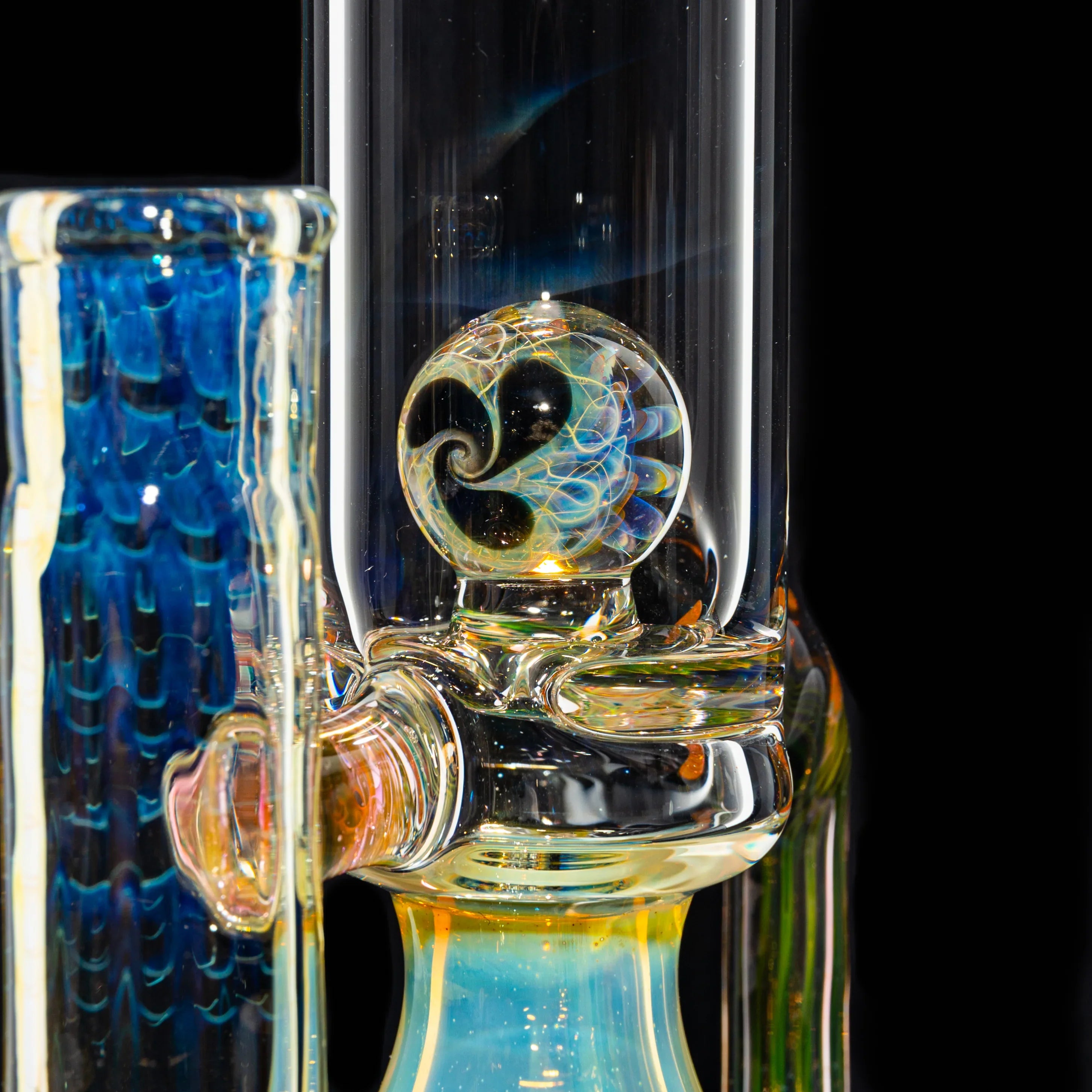 Close-up of a heady glass water pipe with a colorful swirl marble accent and blue details