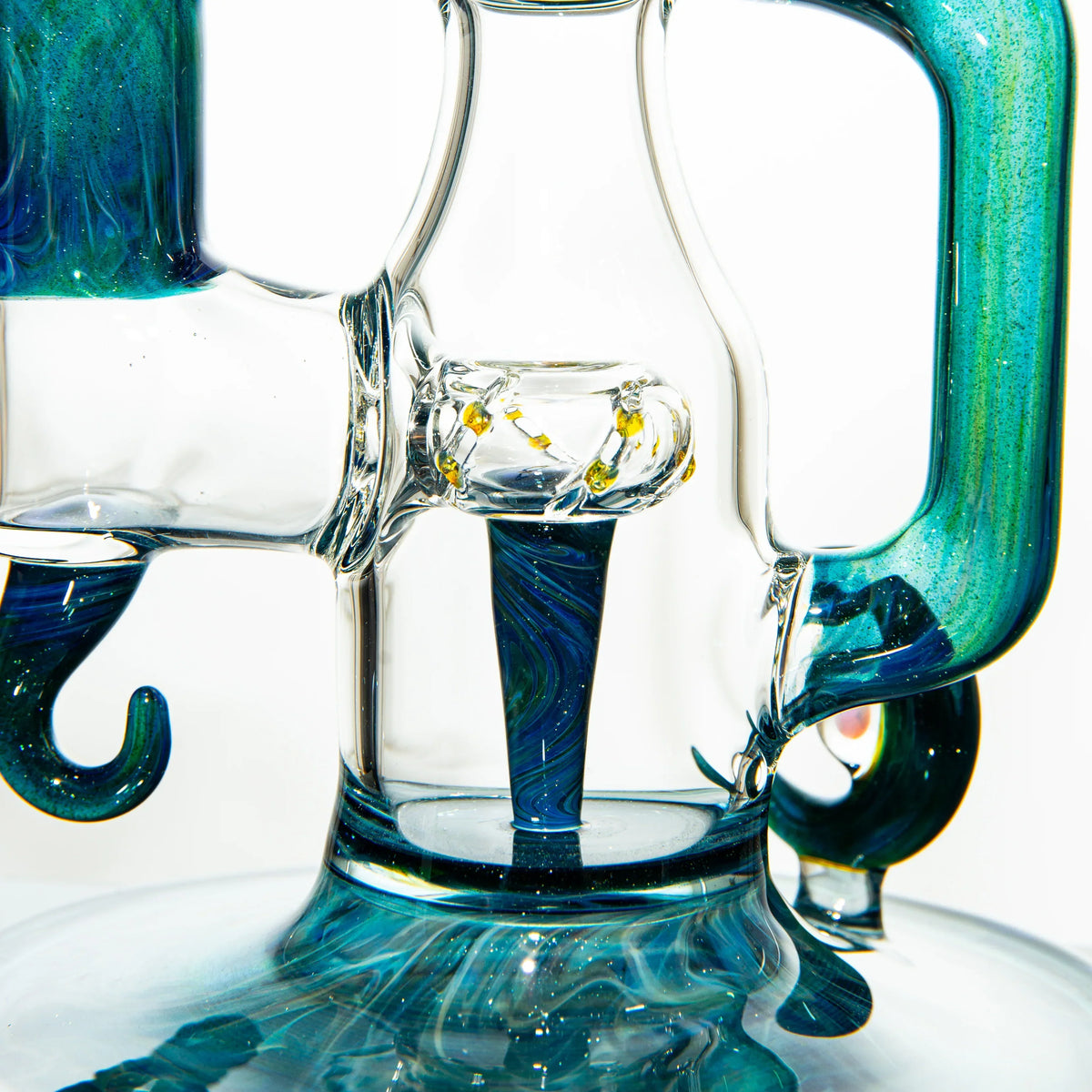 Close-up of a blue and green heady glass water pipe with intricate details and swirling patterns