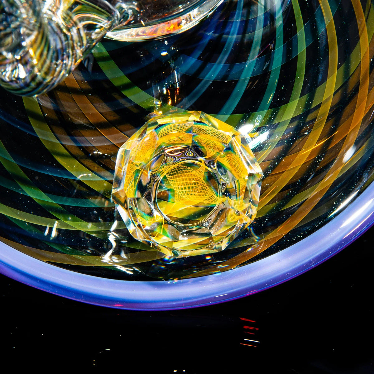 Close-up of colorful glass art with intricate yellow and blue swirling patterns
