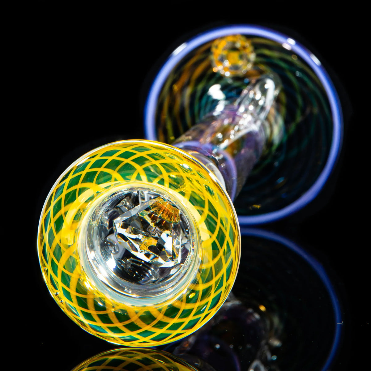 Close-up of a colorful heady glass pipe with intricate yellow and green patterns